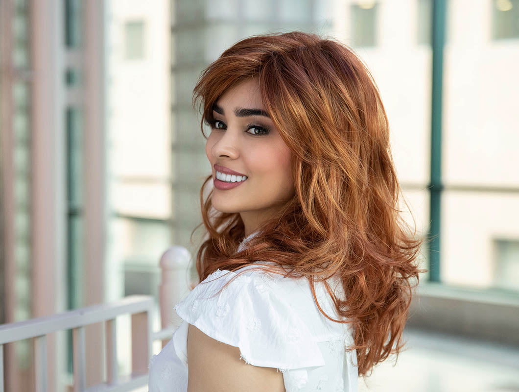profile side of a long Kinner Beauty Wigs wig on woman head