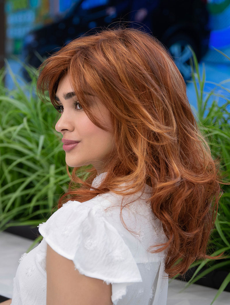profile side of a long Kinner Beauty Wigs wig on woman head
